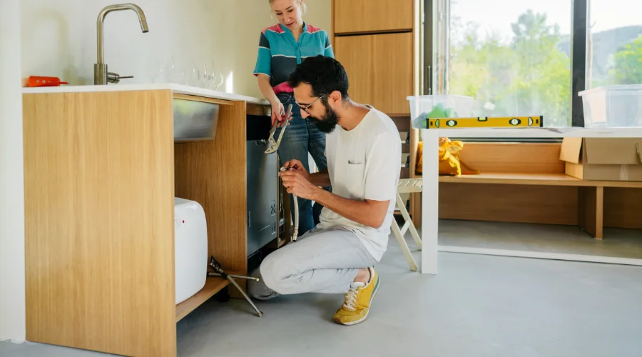 couple fixing kitchen sink